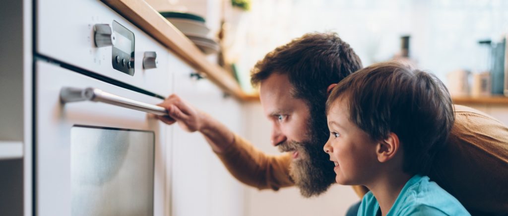 un uomo e un bambino che guardano un forno