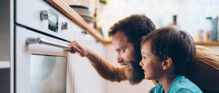 un uomo e un bambino che guardano un forno