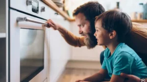 un uomo e un bambino che guardano un forno