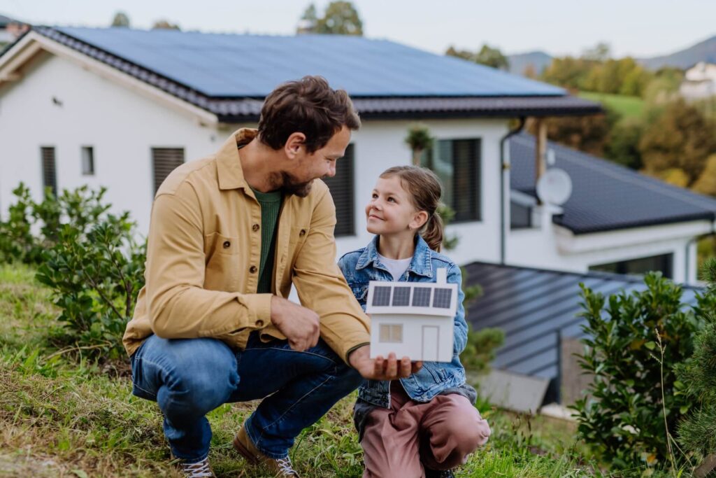a man and girl holding a model of a house
