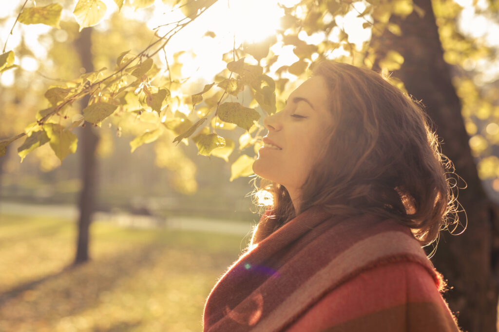 woman standing in the park and enjoying with her eyes closed