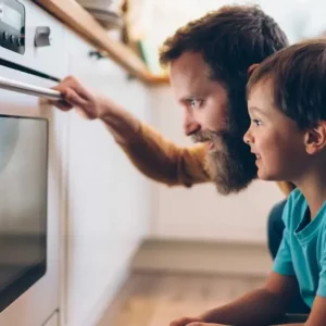 un uomo e un bambino che guardano un forno